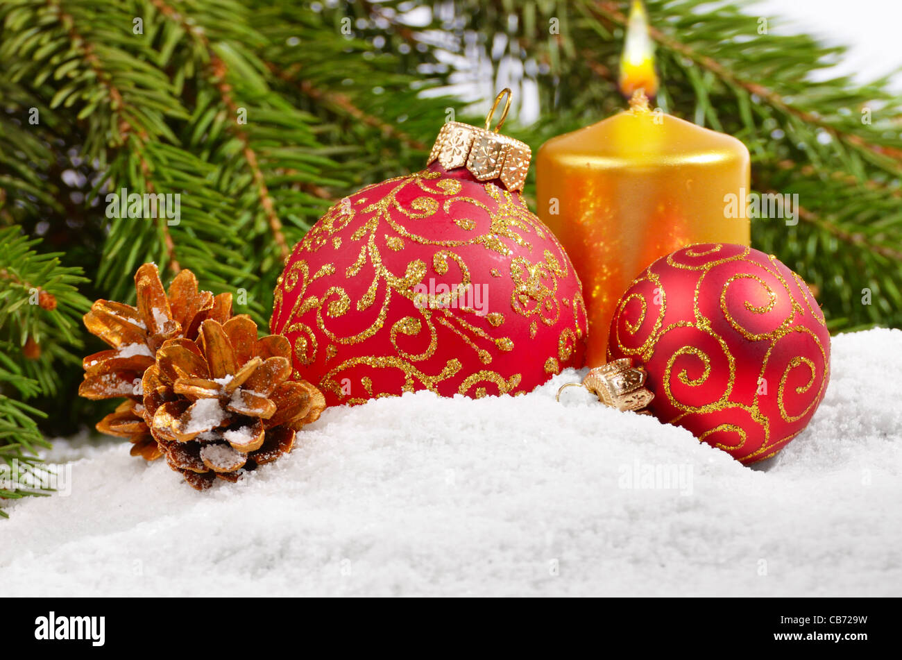 Weihnachtskugeln mit goldenen Kerze in weiß Stockfoto
