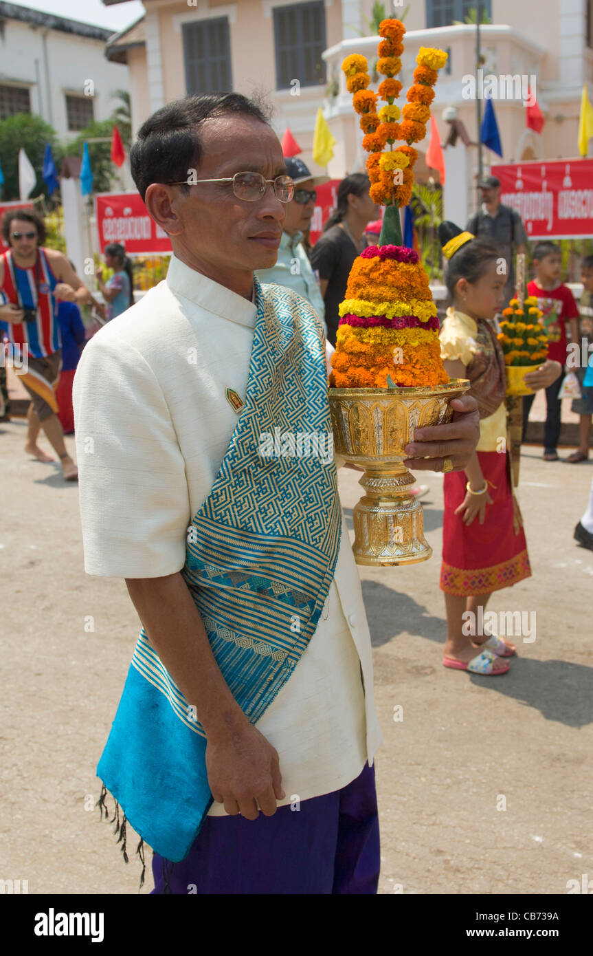 Lao Mann trägt Angebote in einer Prozession auf Mue Nau, der mittlere Tag der Lao Neujahr (Pi Mai Lao), Luang Prabang, Laos Stockfoto