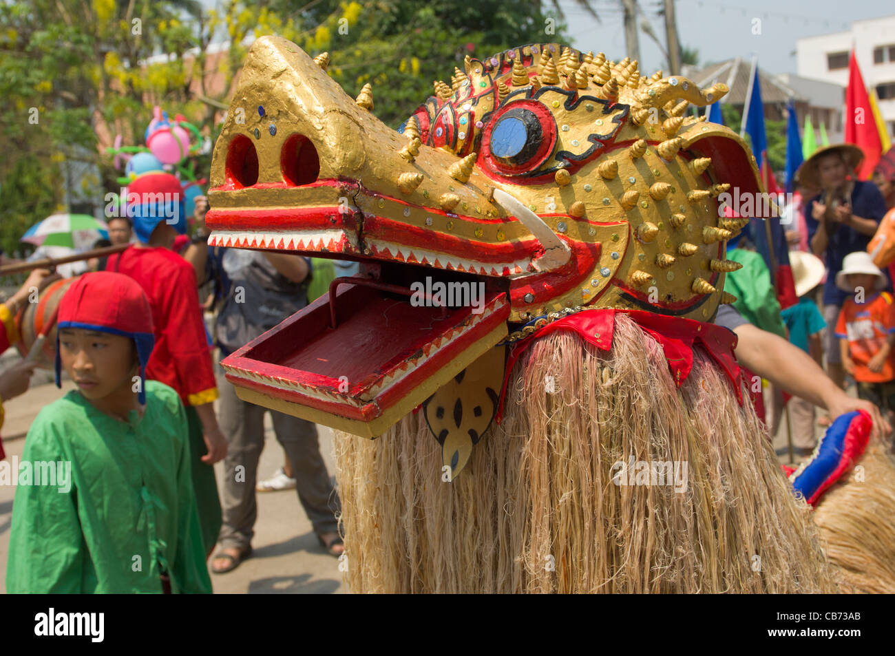 Mythische maskierte Löwe Figur Singkaeo-Singkham in einer Prozession auf Mue Nau, Lao Neujahr (Pi Mai Lao), Luang Prabang, Laos Stockfoto