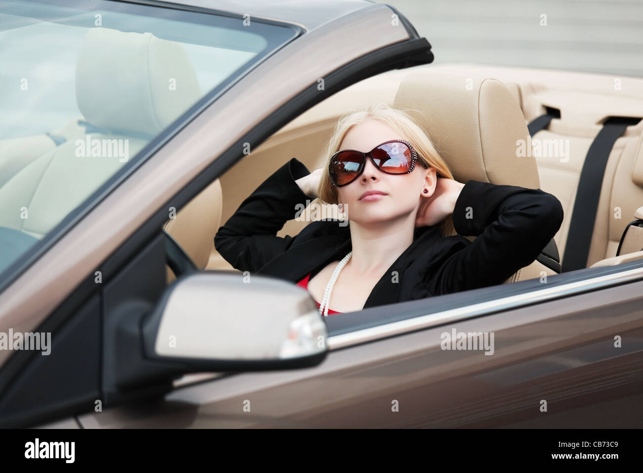 Junge Frau sitzt in einem Cabrio Stockfoto