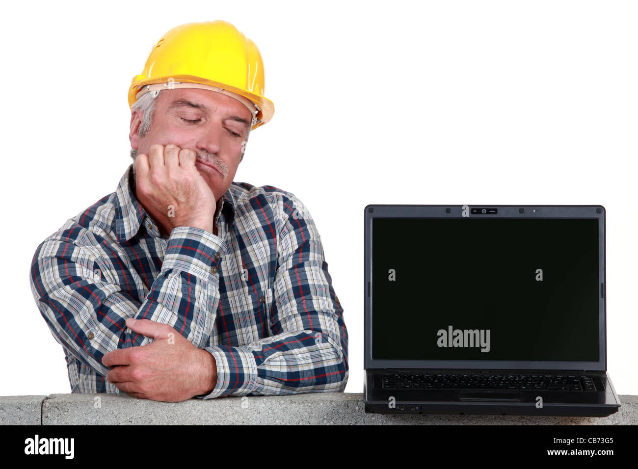 Senior Handwerker posiert neben einem laptop Stockfoto