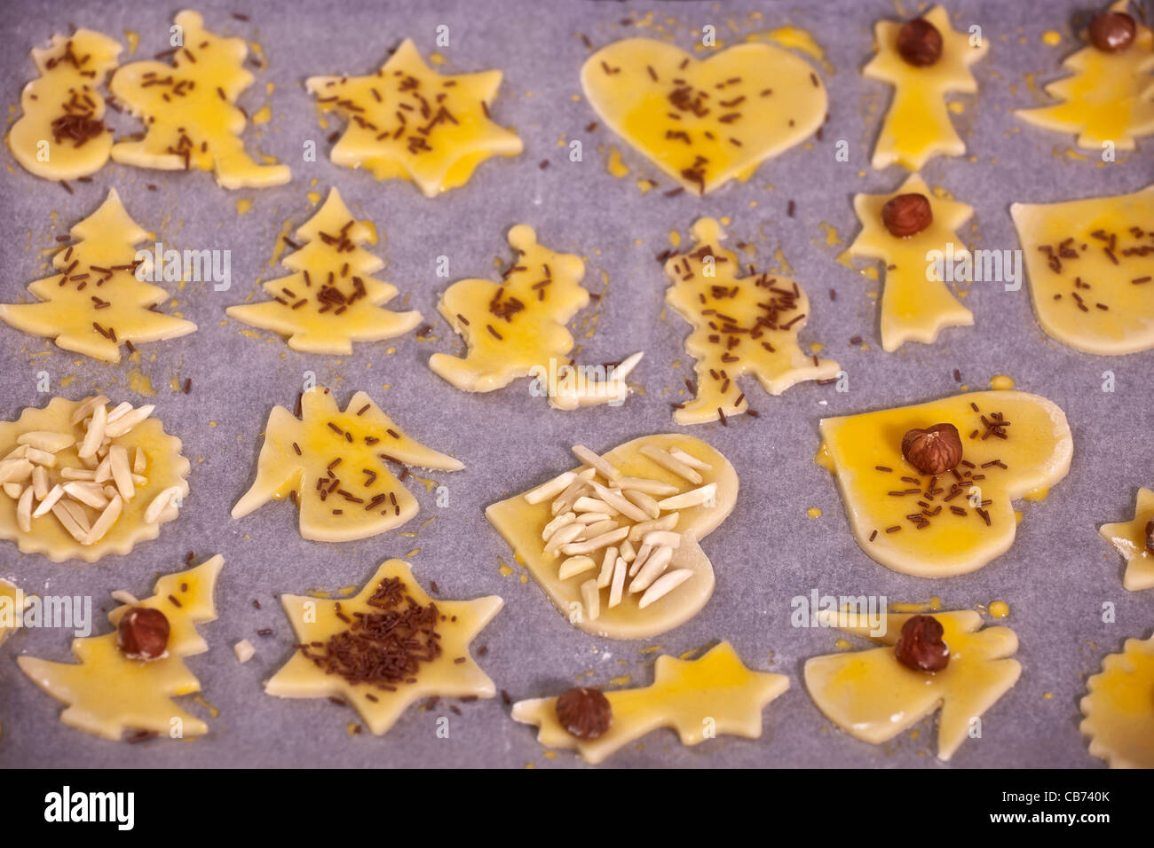 ungebackenen Kekse mit Schokoladenstückchen und gebürstet mit Eigelb, Mandeln und Walnüsse Stockfoto