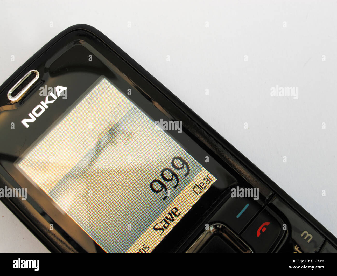 Ein einfaches Nokia Handy auf einem weißen Hintergrund Closeup mit uk Notrufnummer 999 zeigt auf dem Bildschirm Stockfoto