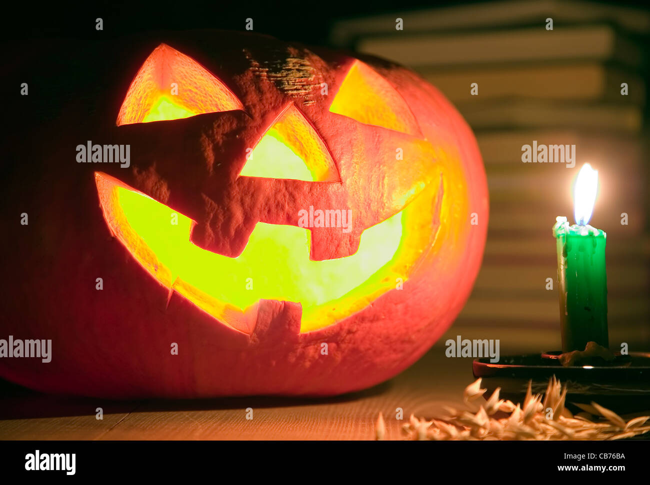 Gruselige Kürbis in der Nähe von Kerze, Halloween-Konzept, Buch-Hintergrund Stockfoto