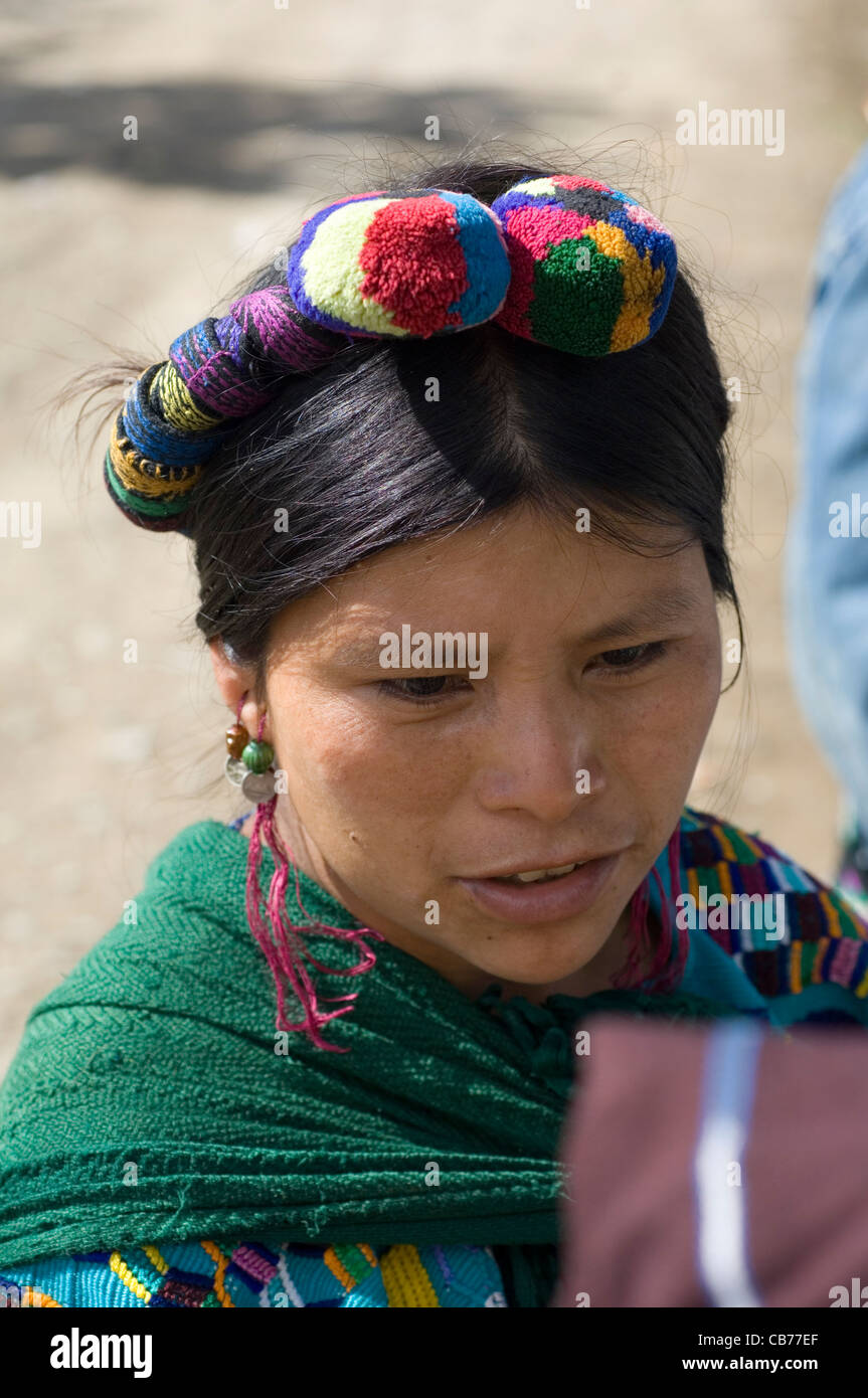 indigenen mittelamerikanischen indische Frau in traditioneller gewebte Kleidung und mit farbigen Zöpfen und Pompons in ihrem Haar. Stockfoto