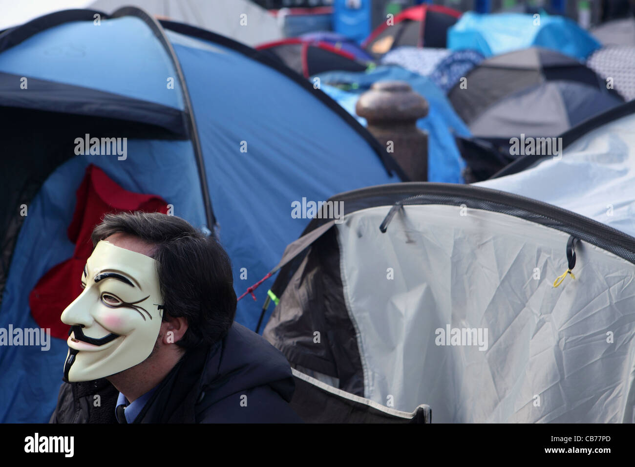 London-Lager, außerhalb der St. Pauls Cathedral, London, UK zu besetzen. Mann, Teil der Anonymous-Bewegung mit Guy Fawkes Maske Stockfoto