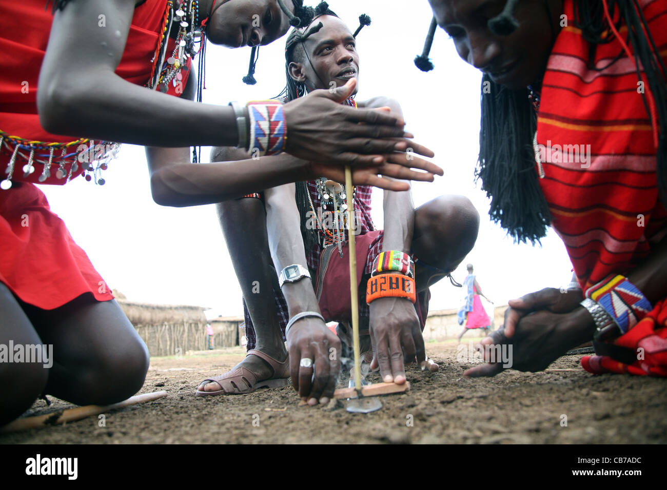 Junge Masai-Männer starten ein Reibungsfeuer, indem sie zwei Stöcke in ihrem Dorf im Masai Mara National Reserve, Kenia, zusammenreiben. 2/2009. Foto: Stockfoto