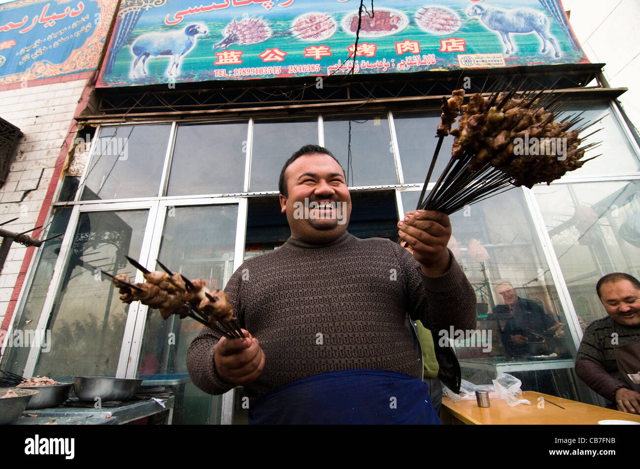 Die Grill-Mann in einem der Kashgars beliebtesten Grill Kebab Restaurant - Guzar Kek Kochkar. Stockfoto