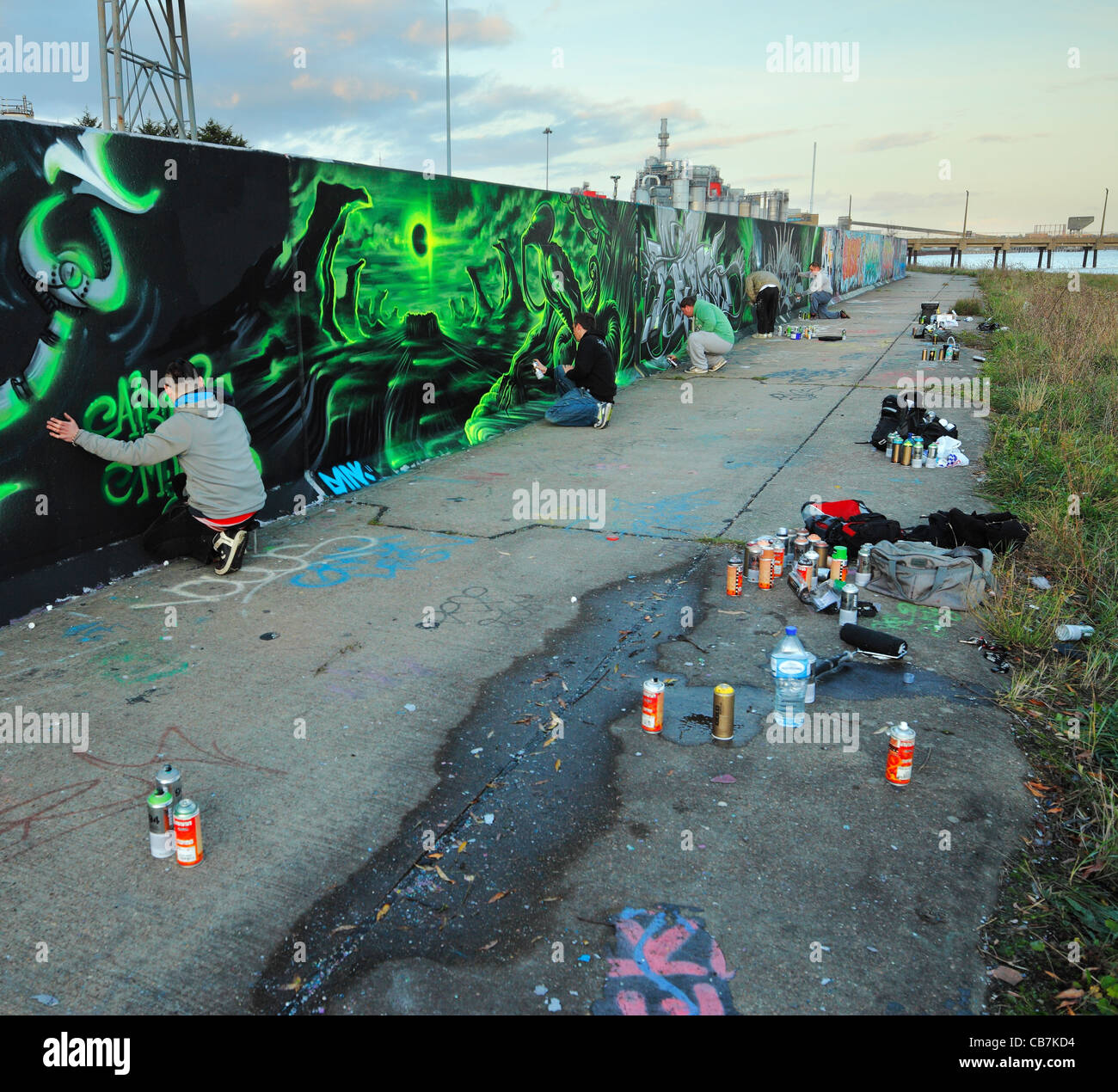 Gruppe von Jugendlichen Spritzlackierung eine rechtliche Graffitiwand. Stockfoto