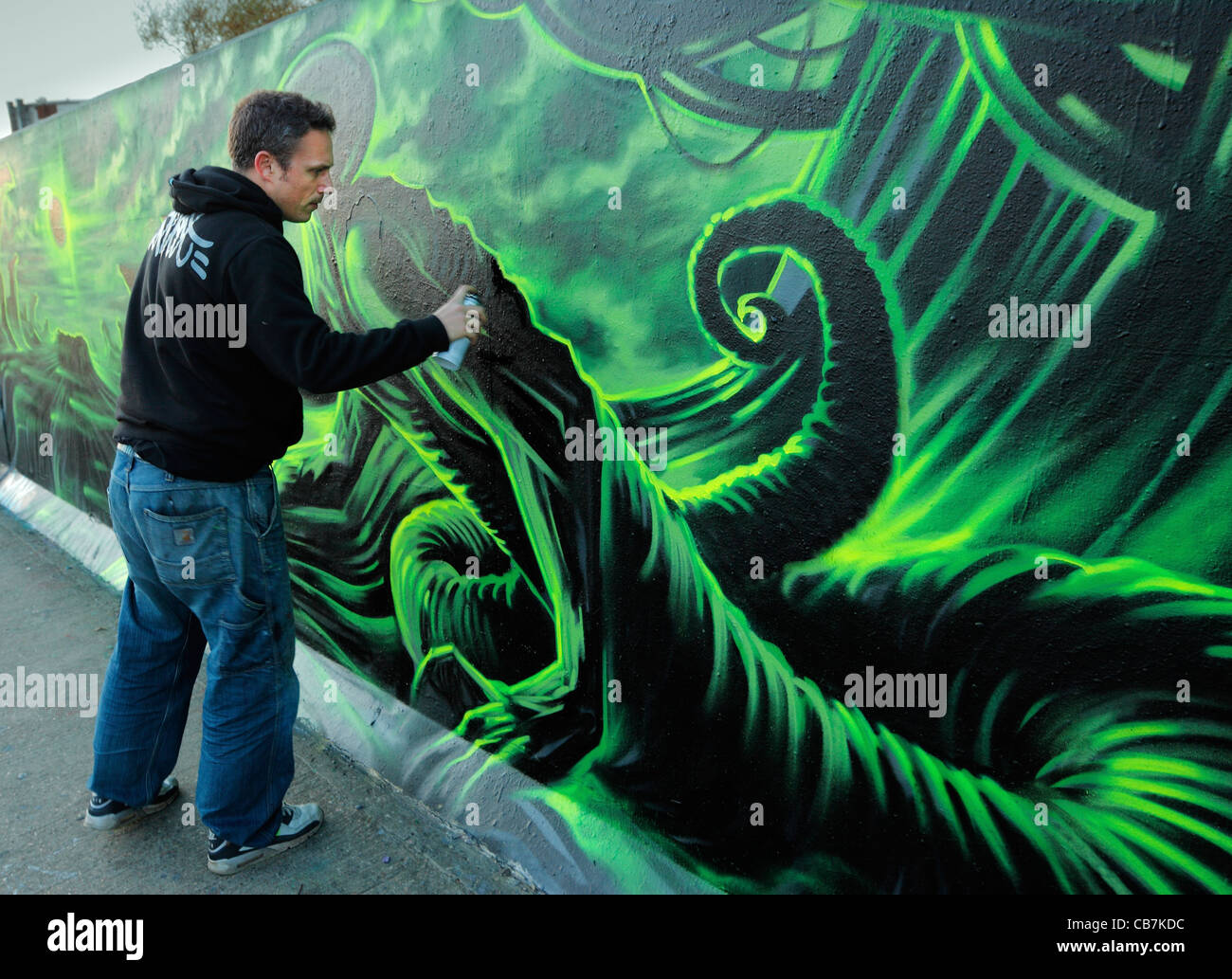 Urbane Künstler Dan Kitchener Malerei eine rechtliche Graffitiwand. Stockfoto