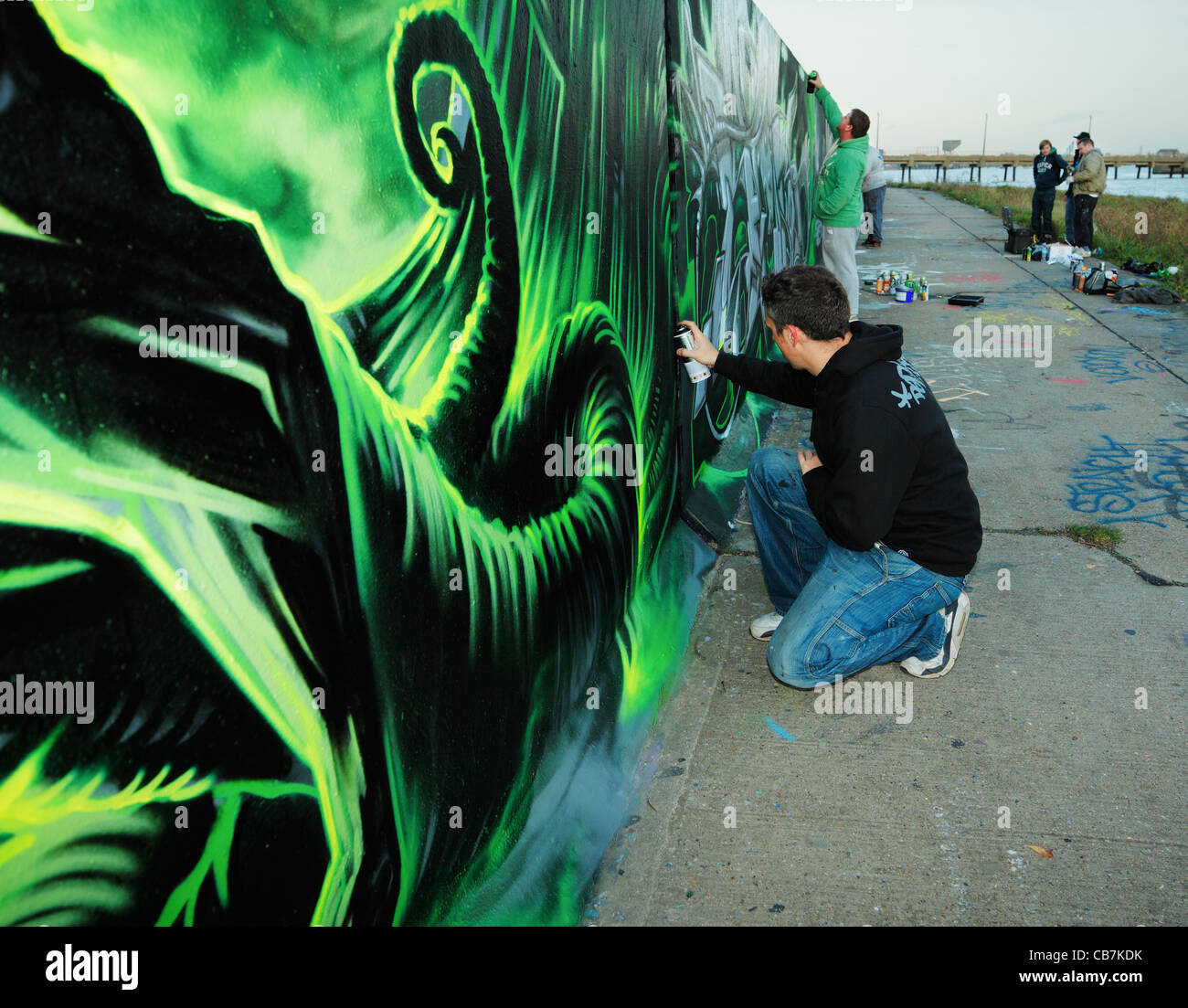 Urbane Künstler Dan Kitchener Malerei eine rechtliche Graffitiwand. Stockfoto