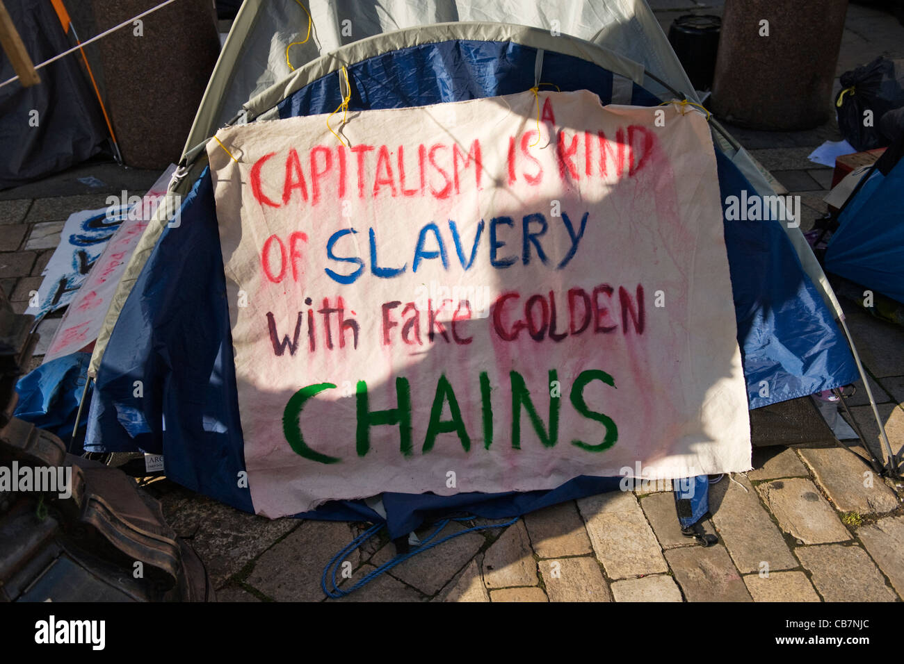 Str. Pauls Kathedrale Tent City besetzen London Aktivisten Banner Kapitalismus ist eine Art von Sklaverei mit goldenen Ketten Fake Stockfoto
