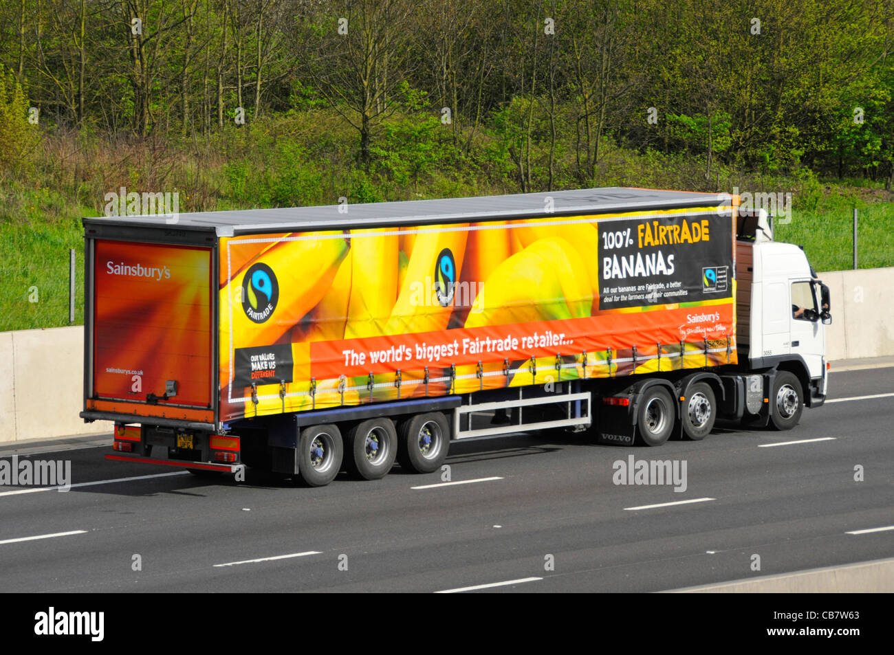 Sainsburys Lebensmittelkette artikuliert Trailer & Lkw Lkw Lkw mit Fairtrade Advert für Bananen einschließlich Fairtrade logo fahren Auf de Autobahn Stockfoto