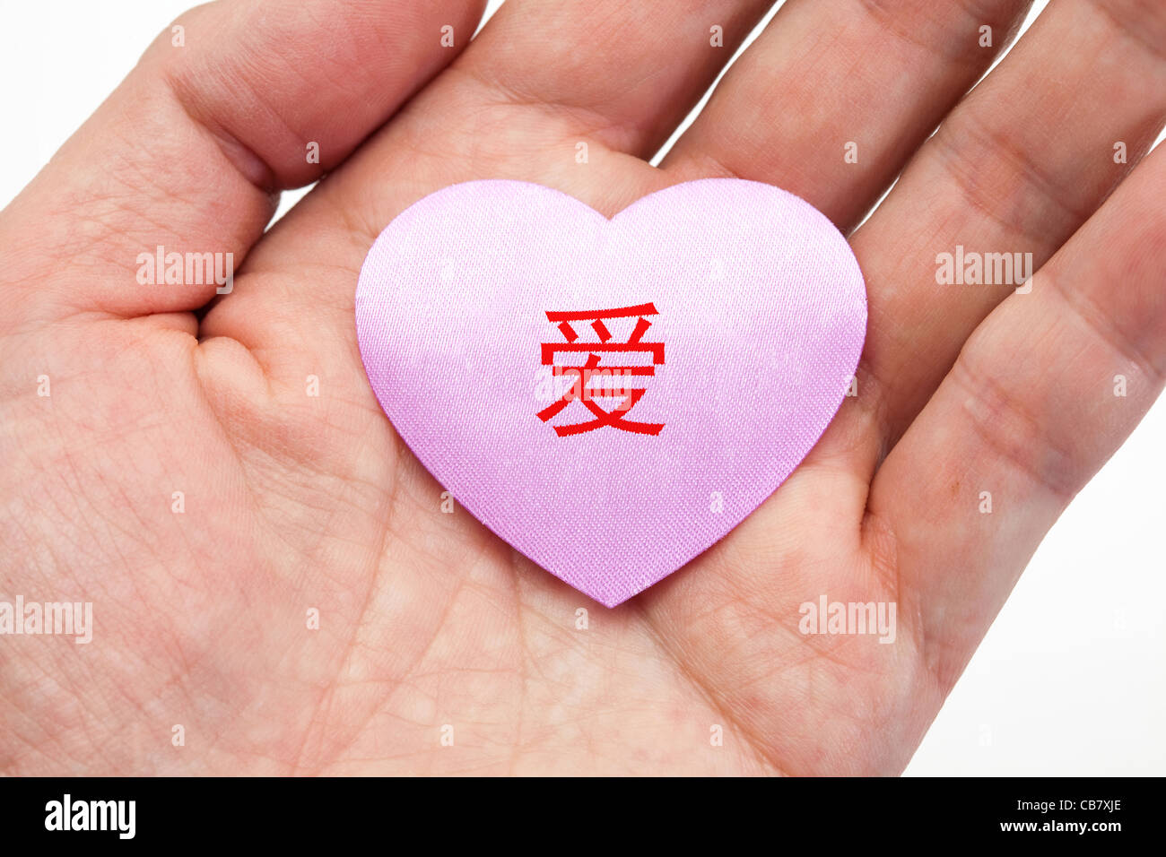 Hand hält ein pinkes Herz mit chinesischen Wort Liebe Stockfoto