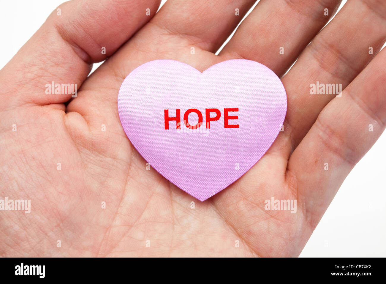 Hand hält ein pinkes Herz, Konzept der Hoffnung Stockfoto