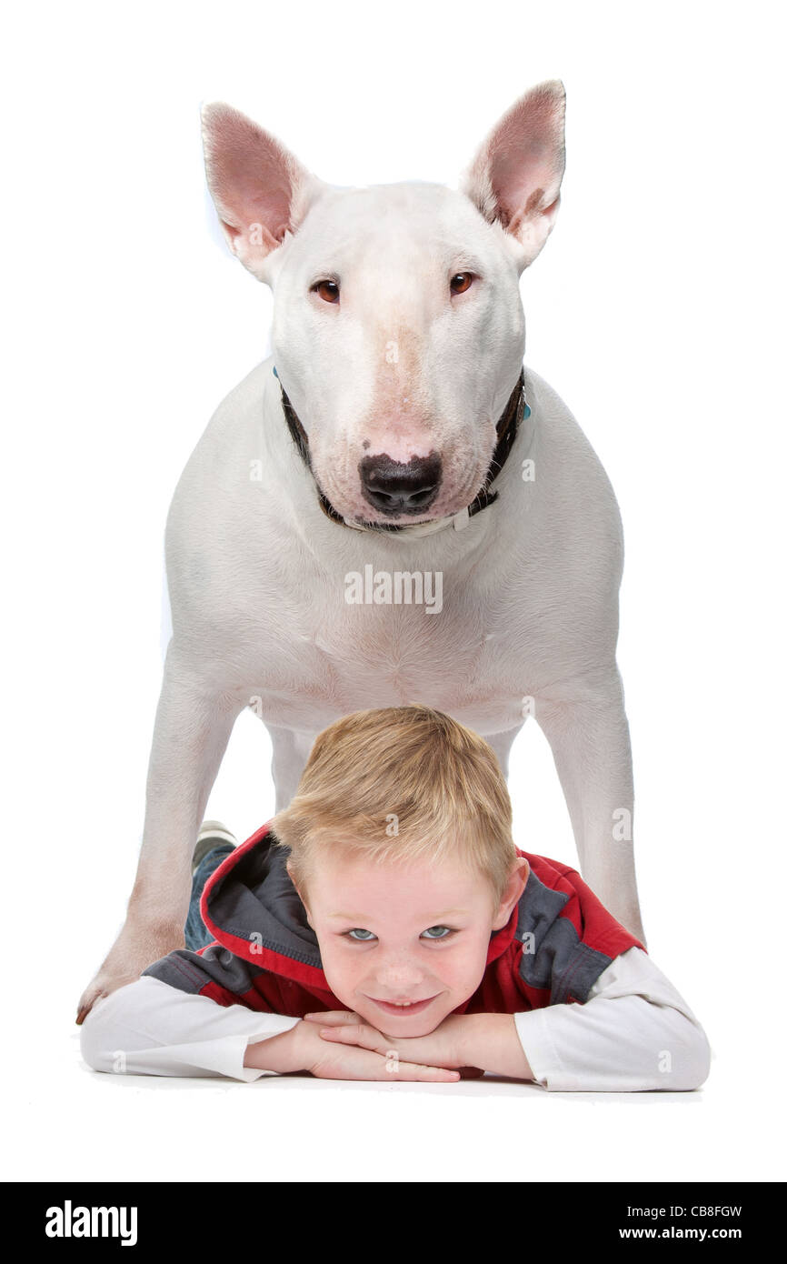 Ein kleiner Junge mit seinem Hund Stand über ihm auf dem Boden liegend Stockfoto