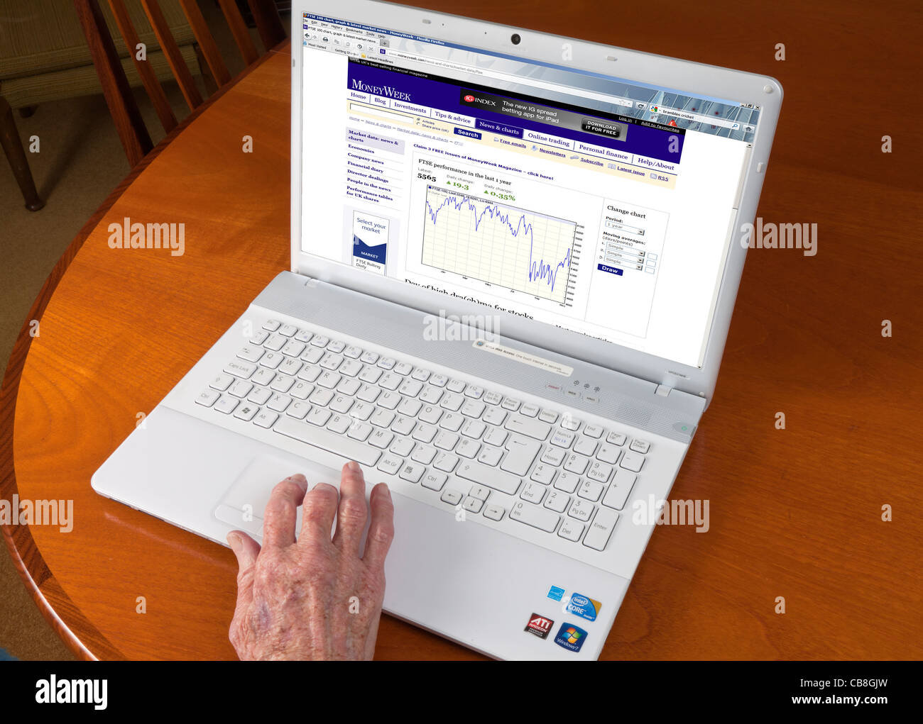 Weiblichen älteren Hand mit einem Laptop an die Finanzmärkten im Internet überprüfen Stockfoto