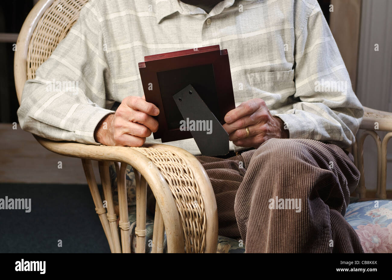 Mann sitzt auf Sessel Blick auf Bilderrahmen Stockfoto