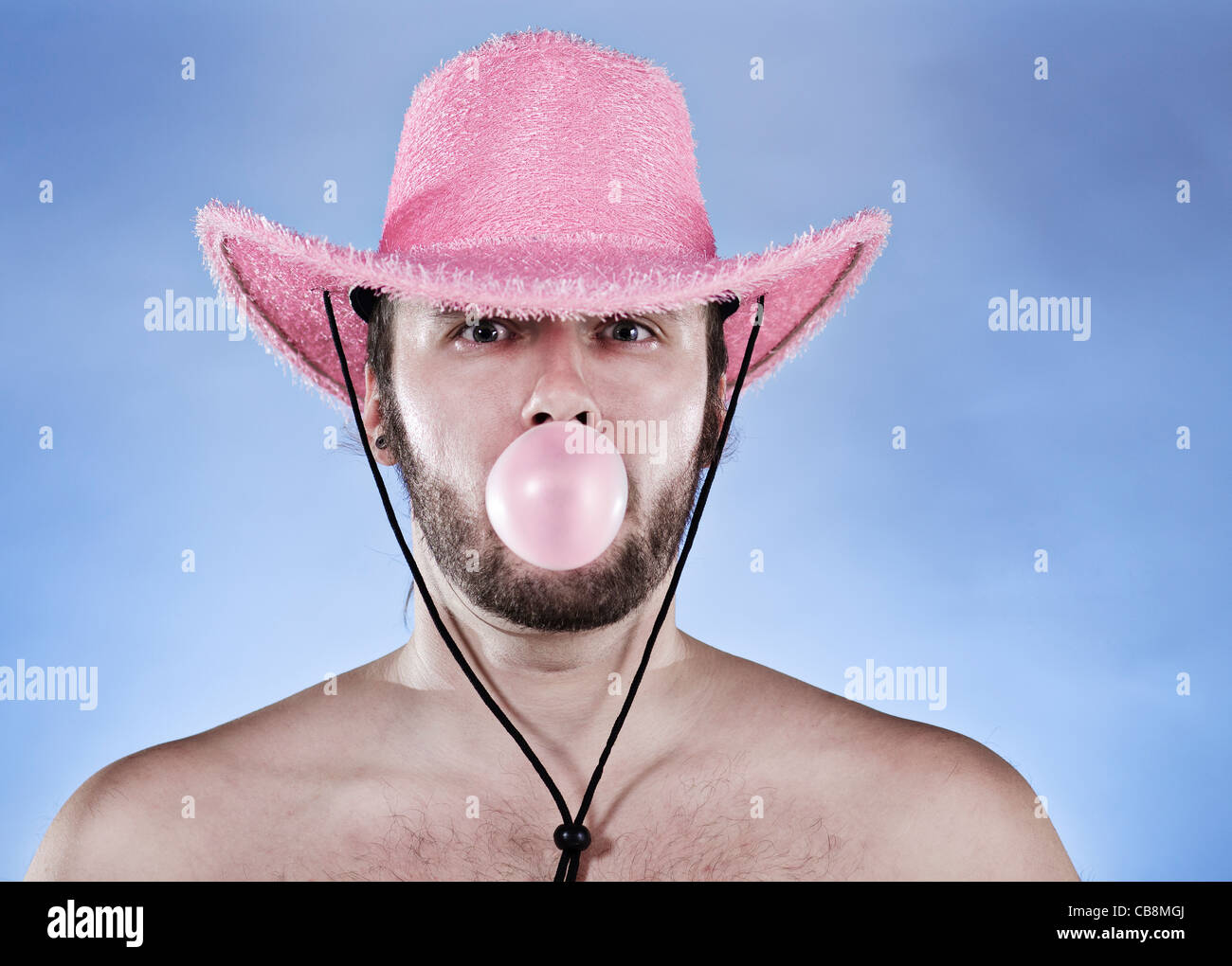Lustige Cowboy in rosa Cowboyhut weht Ping-Ball Kaugummi. Stockfoto