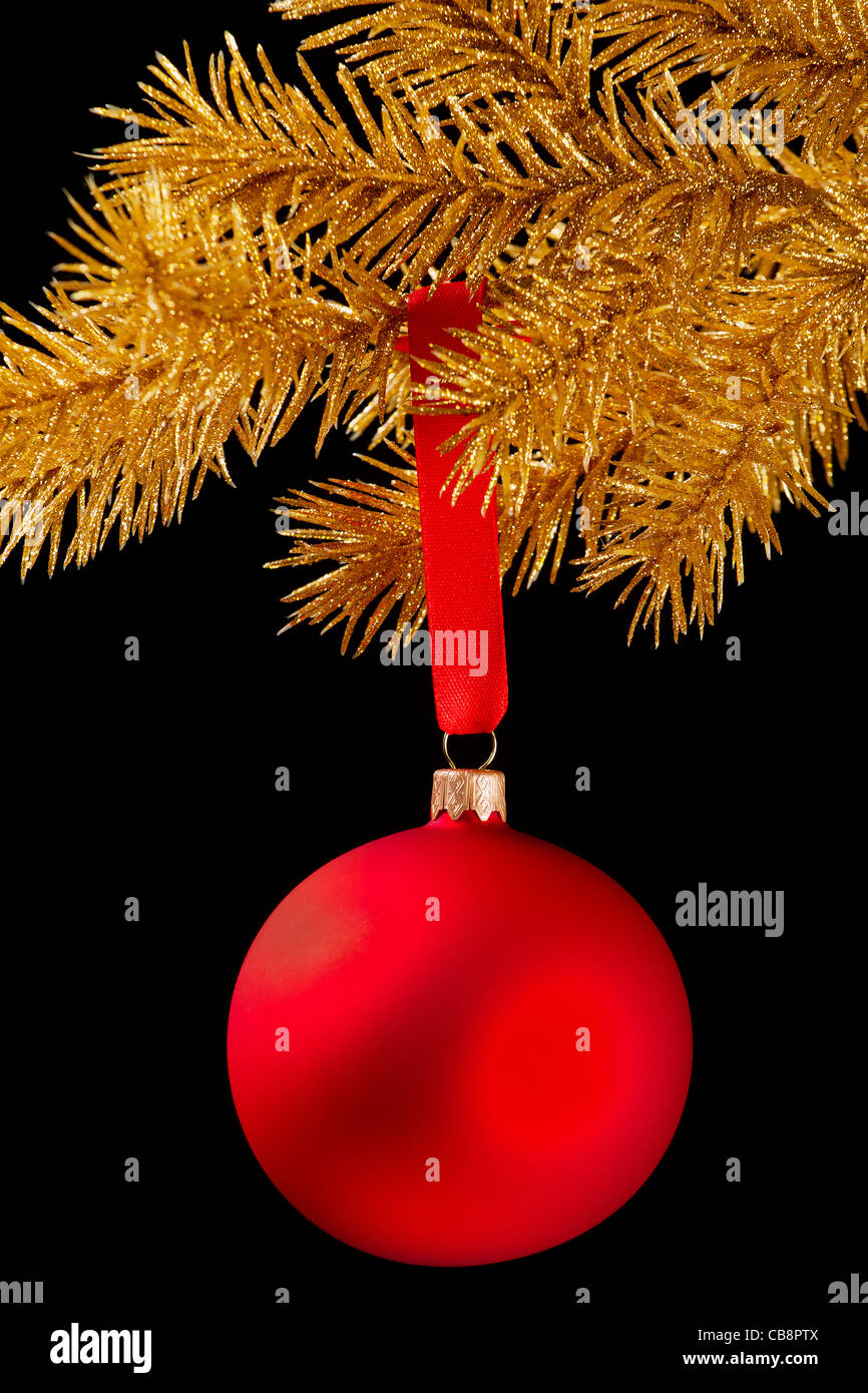 Red Christmas Ball an einem Band auf schwarzem Hintergrund Stockfoto