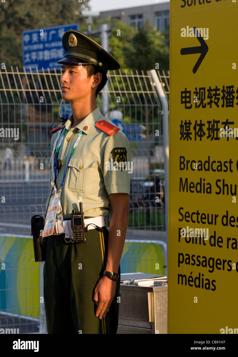 Security Guard in uniform steht neben dem schriftlichen in Chinesisch, Englisch und Französisch bei den Paralympischen Spielen in Peking unterzeichnen Stockfoto