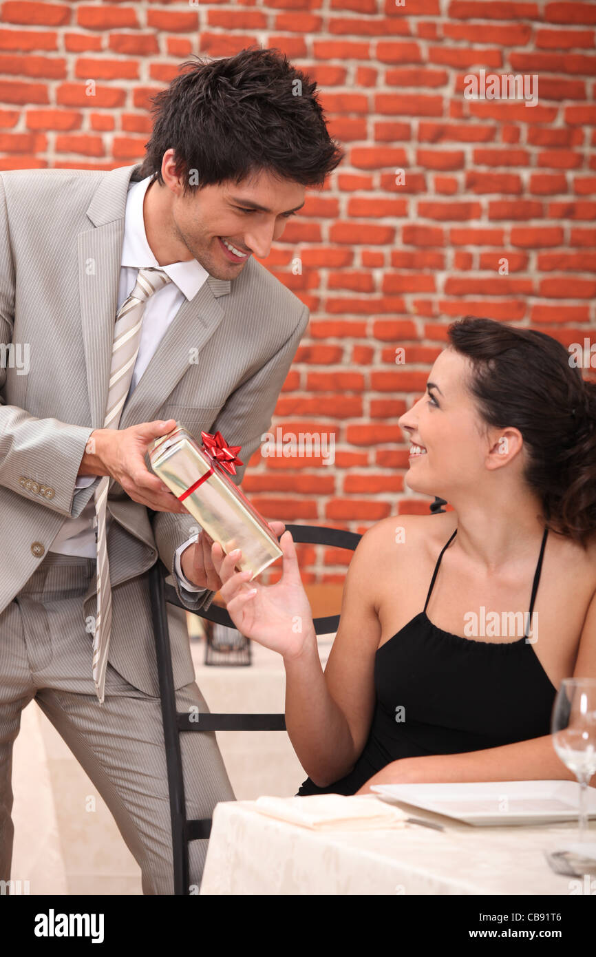 Mann, der ein Geschenk an seine Freundinnen in einem restaurant Stockfoto