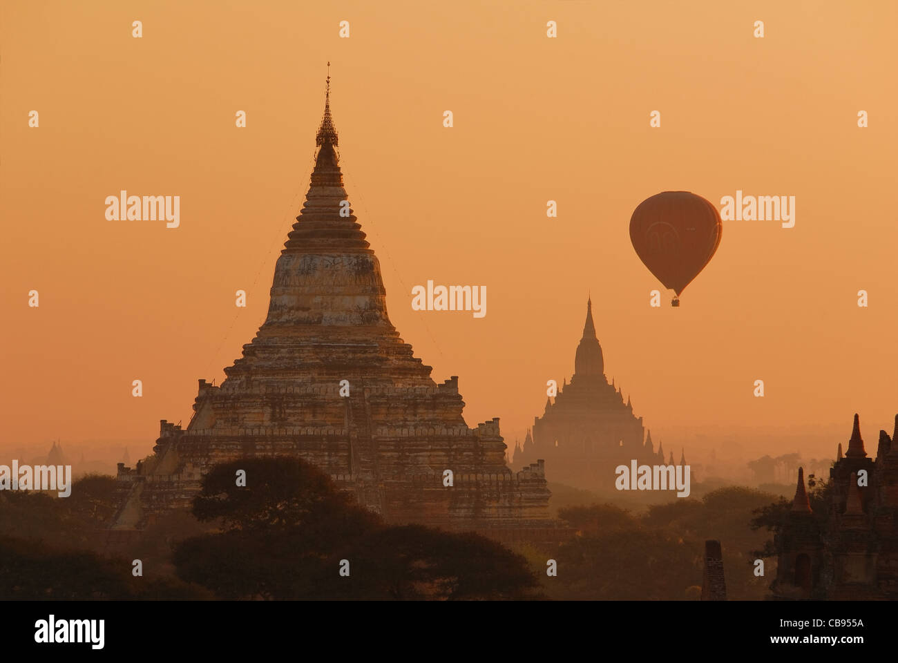 Heißluftballon mit buddhistischen Stupas in orange Morgenlicht in Bagan, Myanmar. Stockfoto
