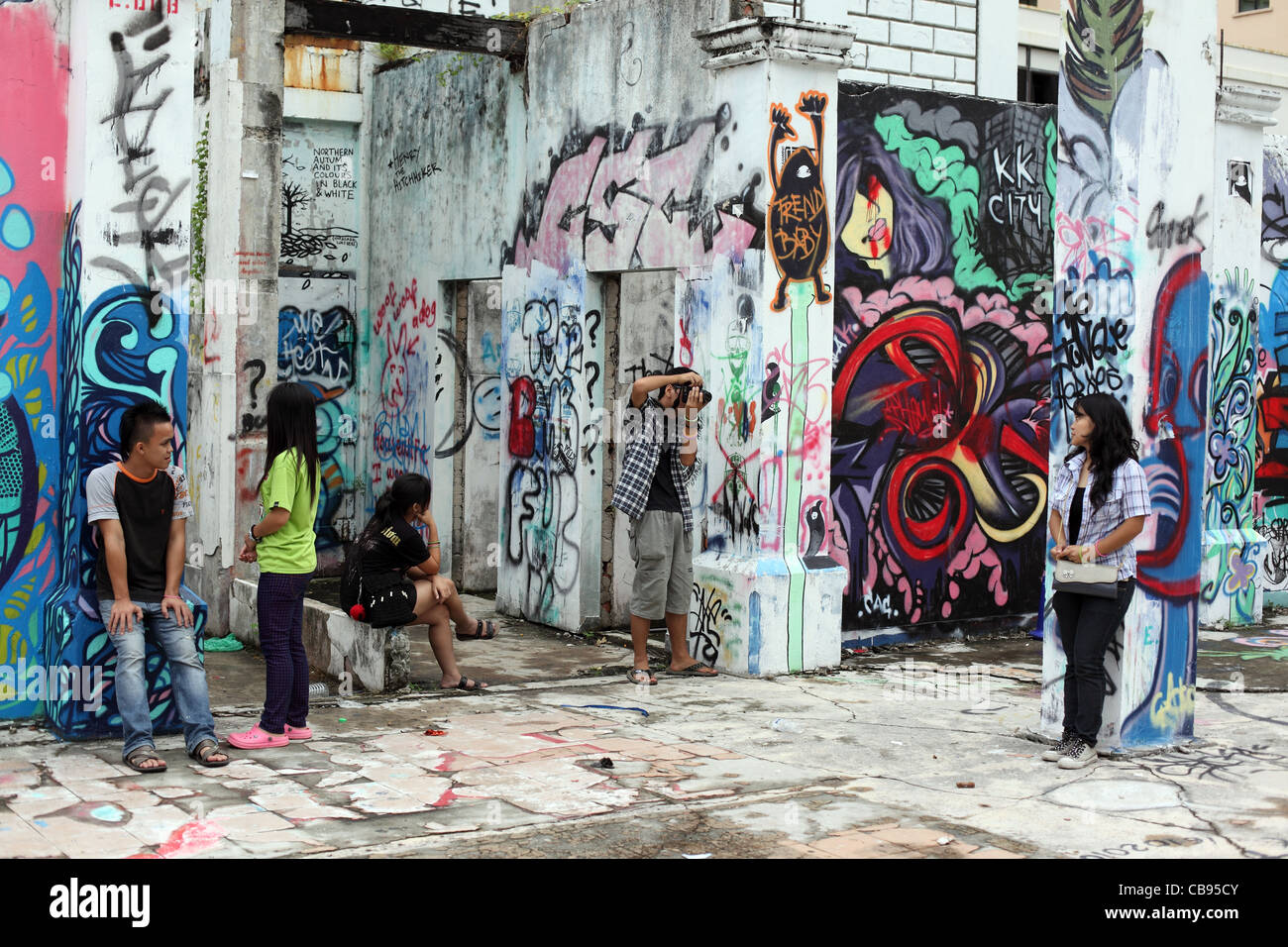 Malaysische Jugend hanging out auf einer abgerissenen Baustelle in Graffiti bedeckt. Kota Kinabalu, Sabah, Borneo, Malaysia Stockfoto