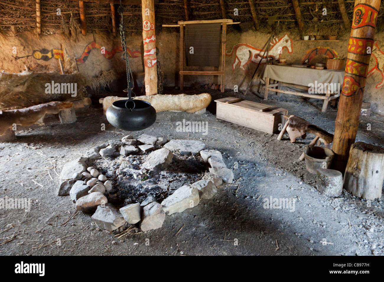 Innenraum eines Replikats neolithischen reetgedeckten Haus mit Kamin Stockfoto