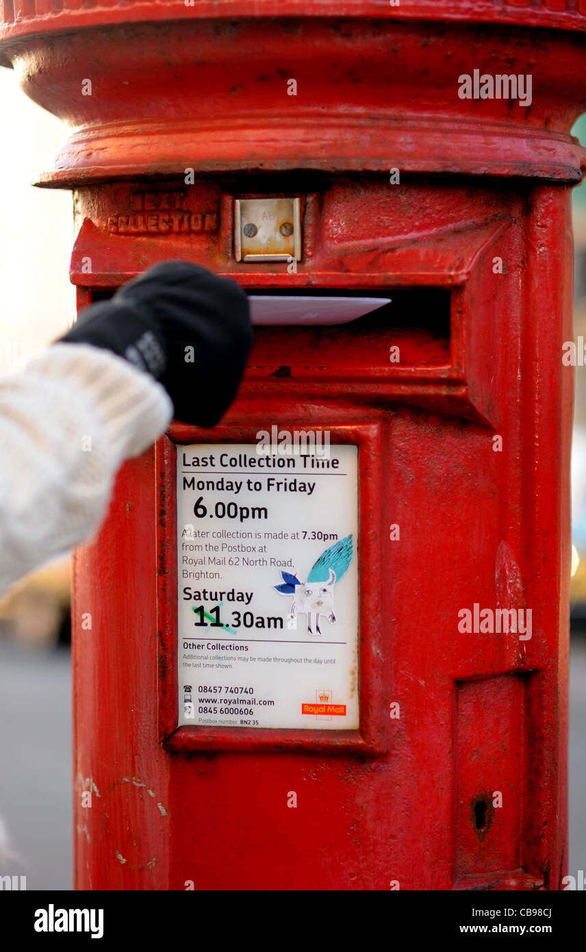 Buchen eine Weihnachtskarte in britischen roten Briefkasten in Time UK Stockfoto