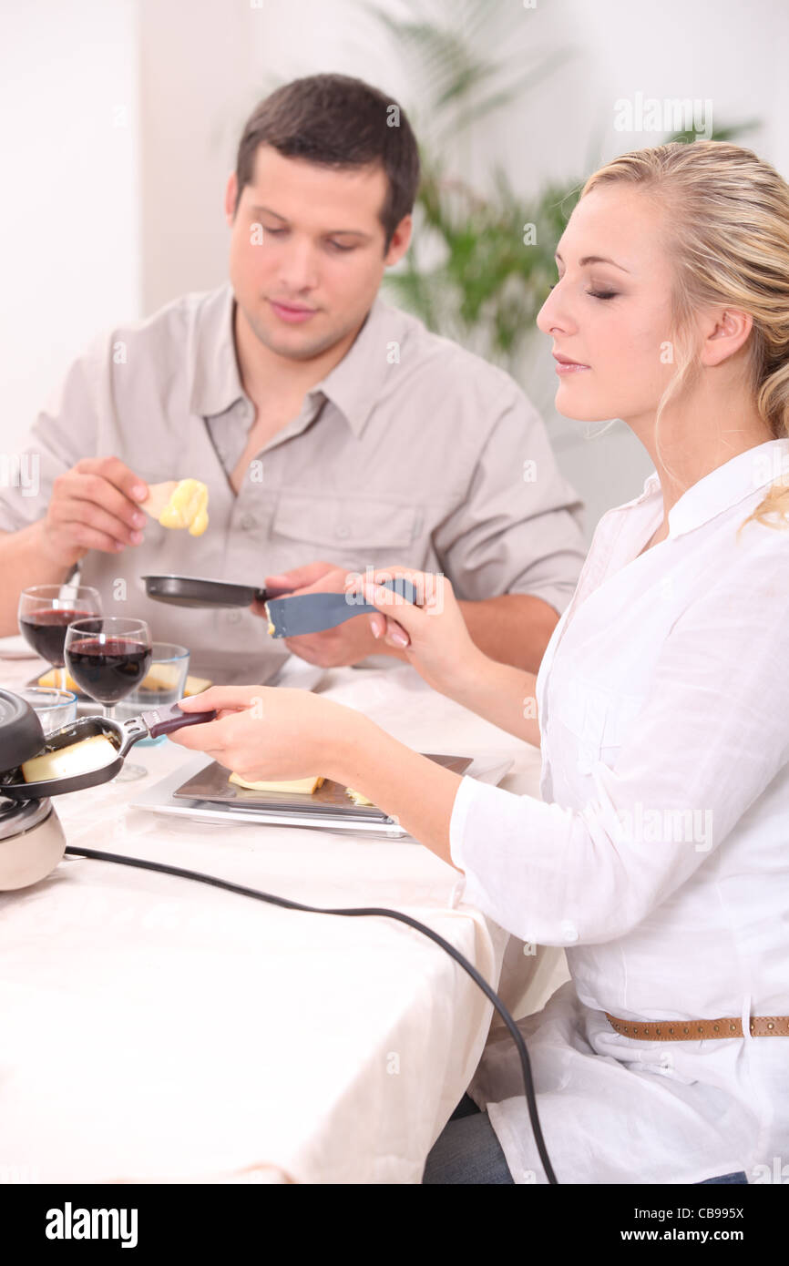 Paar Raclette Essen Stockfoto