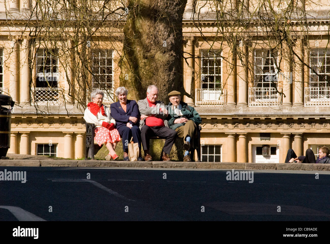 Zwei Damen und zwei Herren sitzen auf einer Parkbank in Stadt Zentrum Bath, England, UK Stockfoto