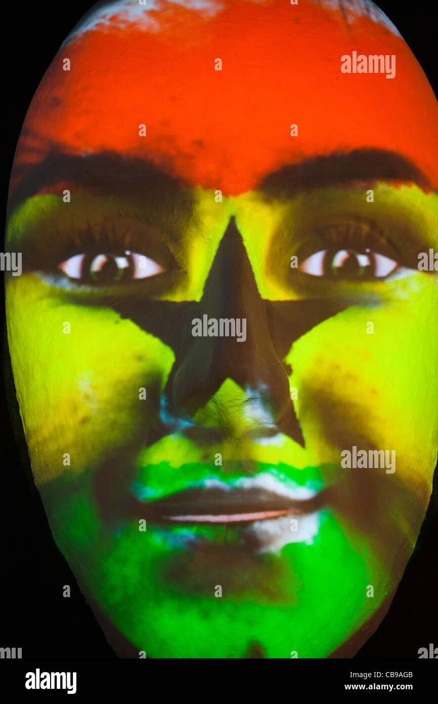 Riesige Skulptur eines Gesichts beleuchtet durch ein Bild von einem ghanaischen Fahne bemaltem Gesicht während des Festival of lights 2011 in Berlin Stockfoto