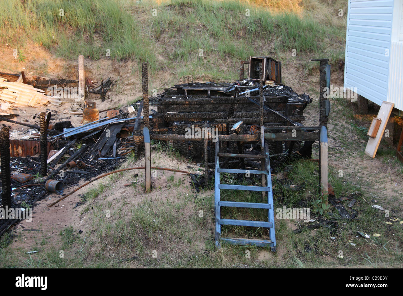 Strandhütte in Sanddünen ausgebrannt, brannte Verkohlte Überreste Holzgebäude Stockfoto