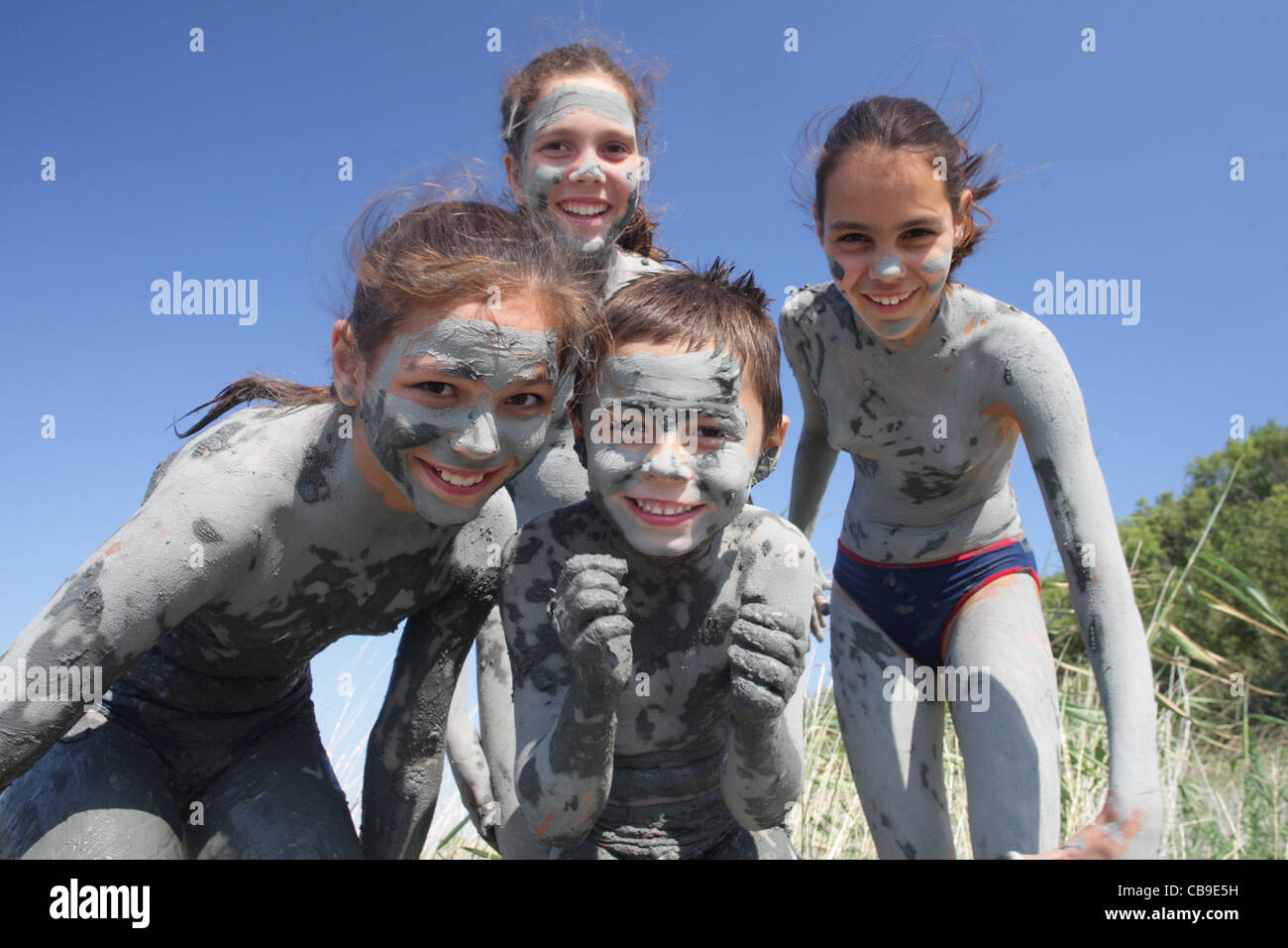 Kinder mit heilendem Schlamm bedeckt spielen am Strand, Tuzlata Resort in der Nähe von Stadt Balchik, Schwarzmeerküste, Bulgarien Stockfoto