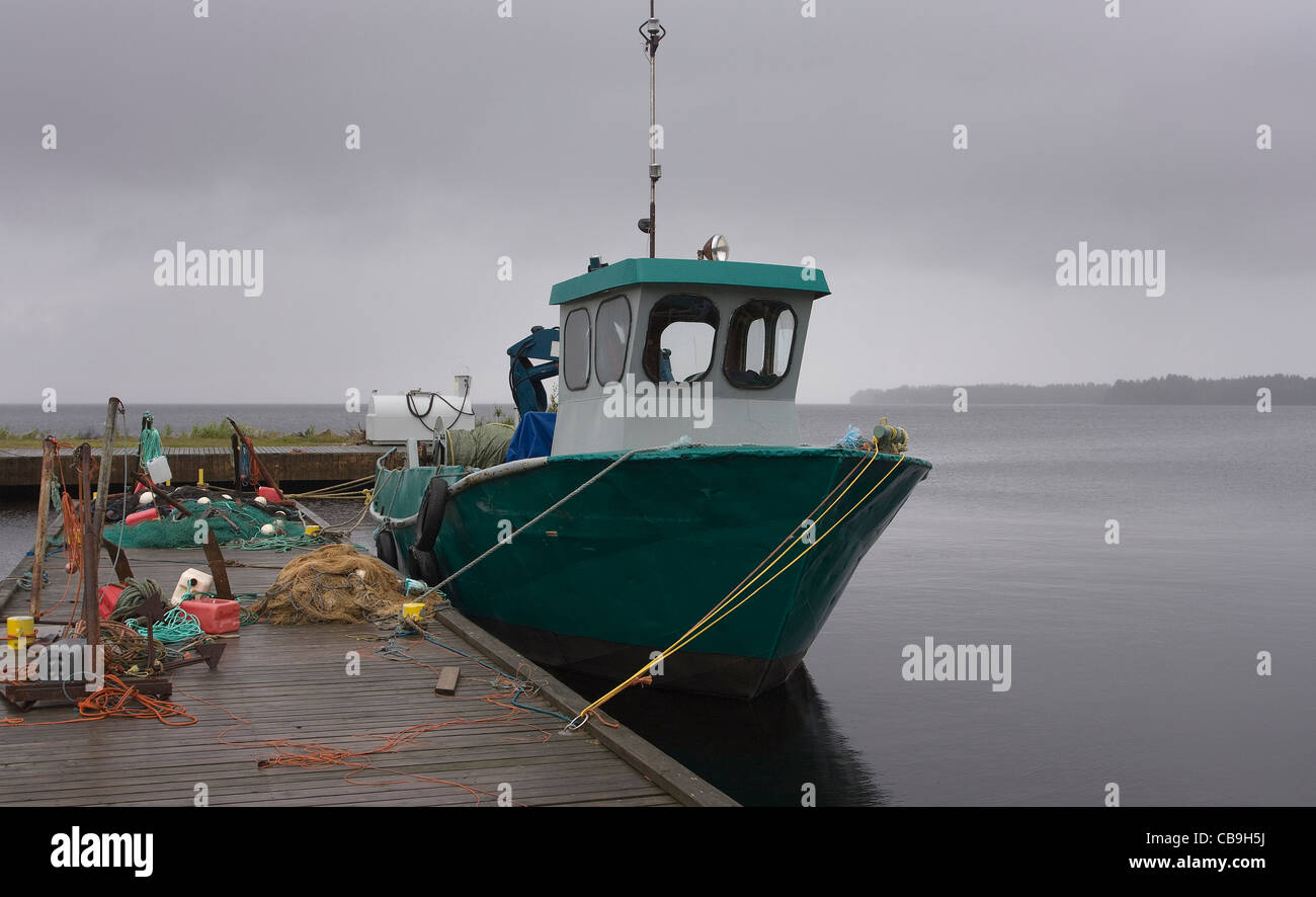 Ein Trawler im kleinen Fischerhafen am See Oulujärvi in Nordfinnland an regnerischen Sommertag. Stockfoto