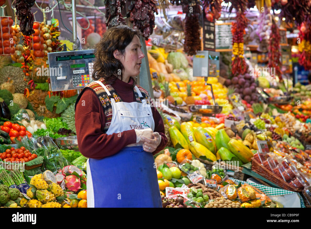 Frau verkaufen frisches Obst und Gemüse im Stall auf dem La Boqueria-Markt in Barcelona, Spanien Stockfoto
