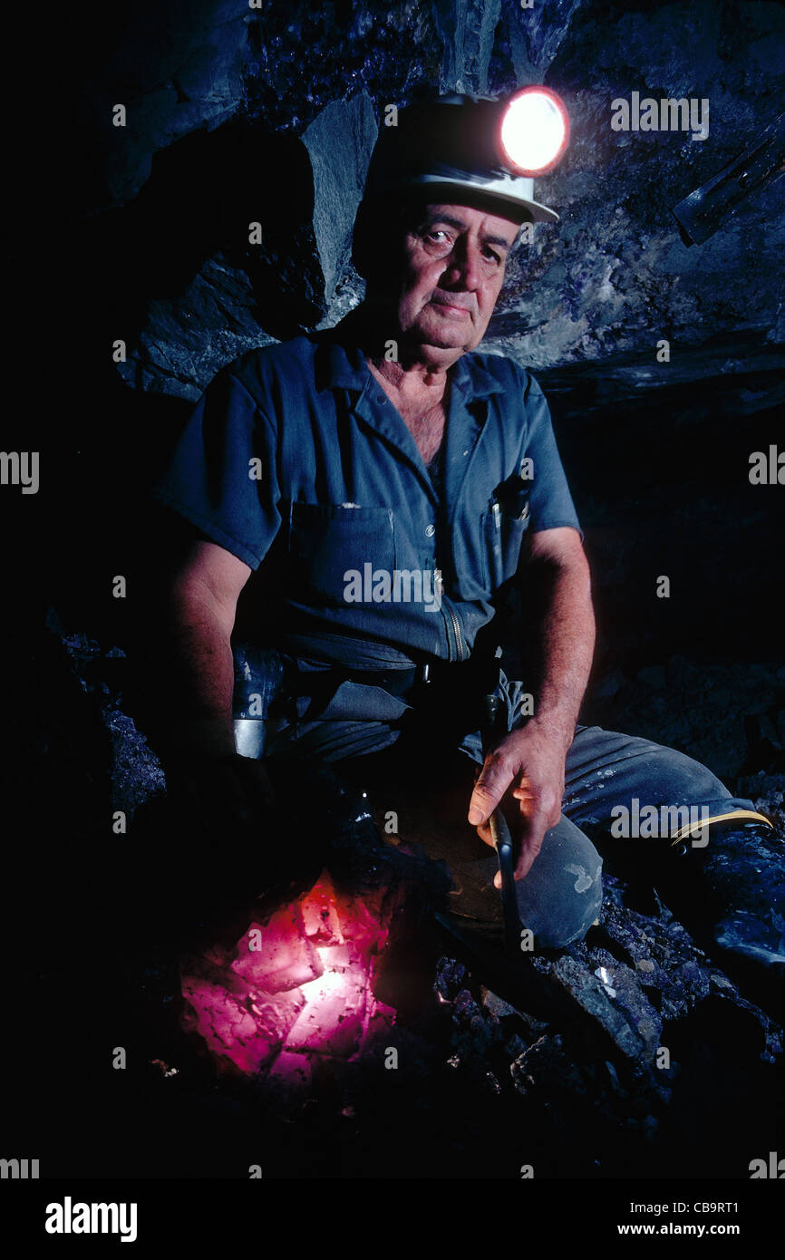 Bergmann in einem Bergwerk Flussspat (Fluorit) verwendet eine Taschenlampe, um durchscheinende Mineral zu beleuchten; Illinois, USA Stockfoto