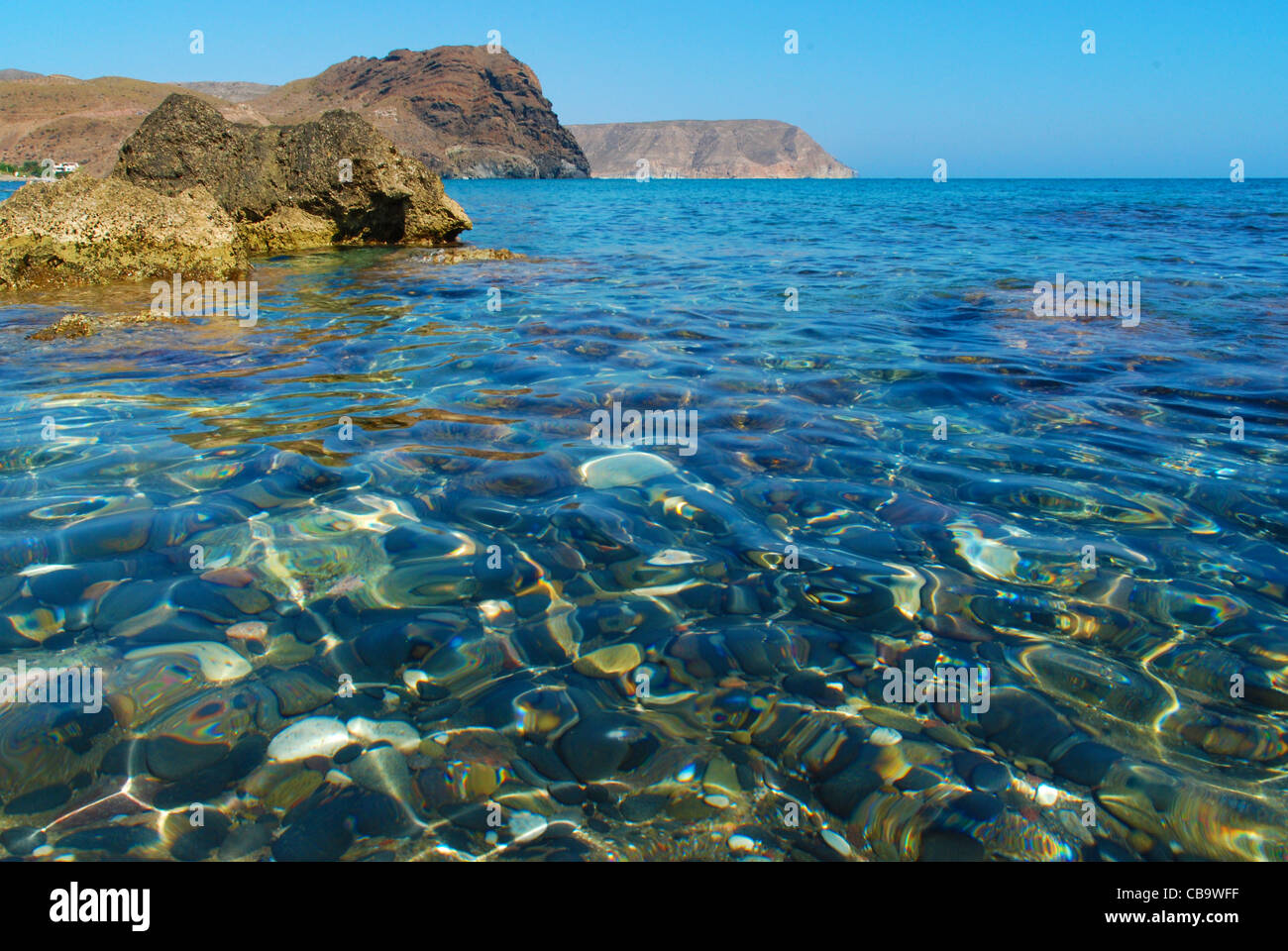 Eine schöne Ansicht vom Strand Playa de Las Negras, zeigt das kristallklare Mittelmeer Wasser, Klippen Felsen & schwarzen Steinen Stockfoto