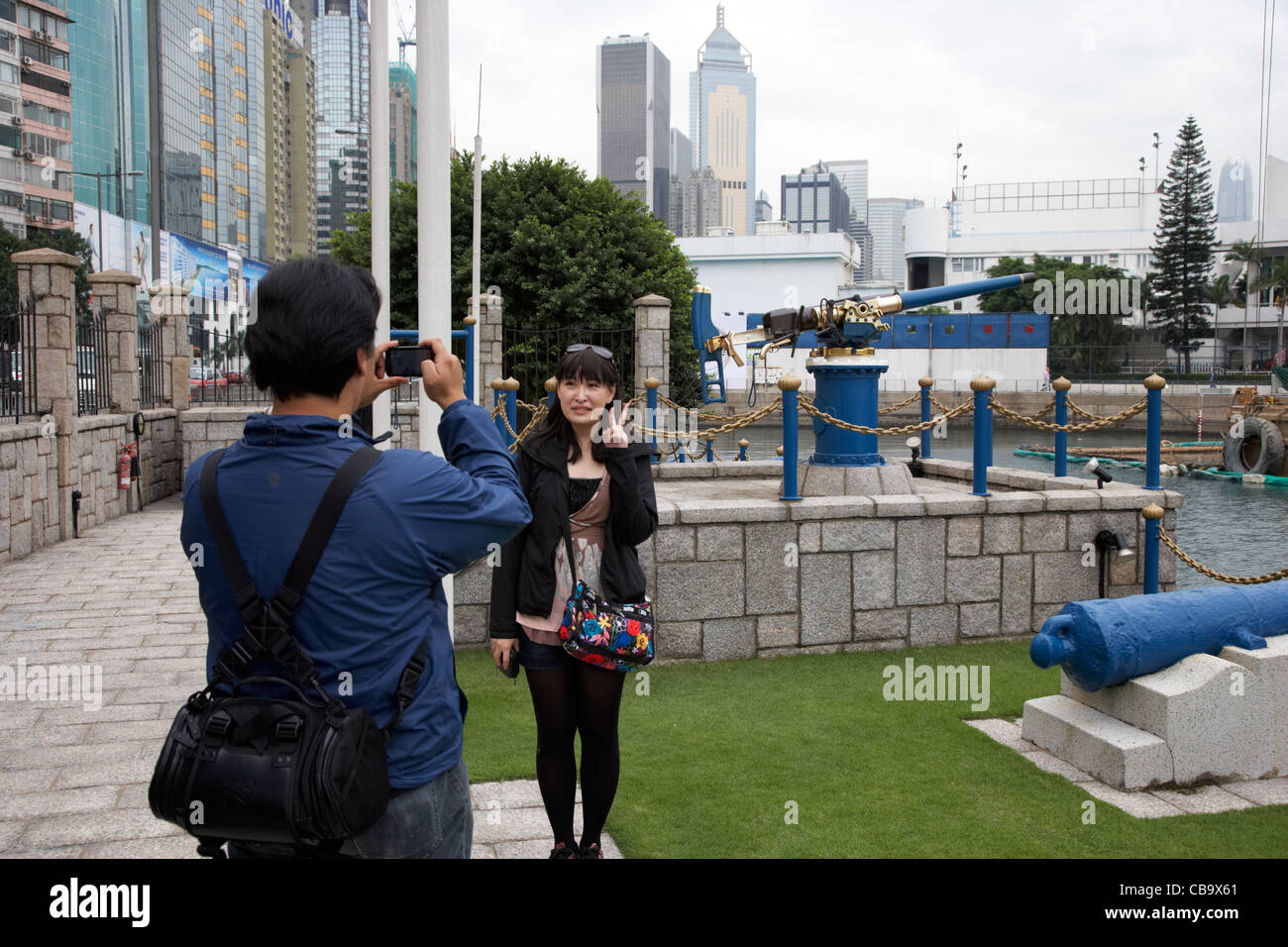 chinesische weibliche Touristen posiert für Foto in Jardines Noonday Gun nach dem Mittag feuern in Hongkong Sonderverwaltungsregion Hongkong china Stockfoto