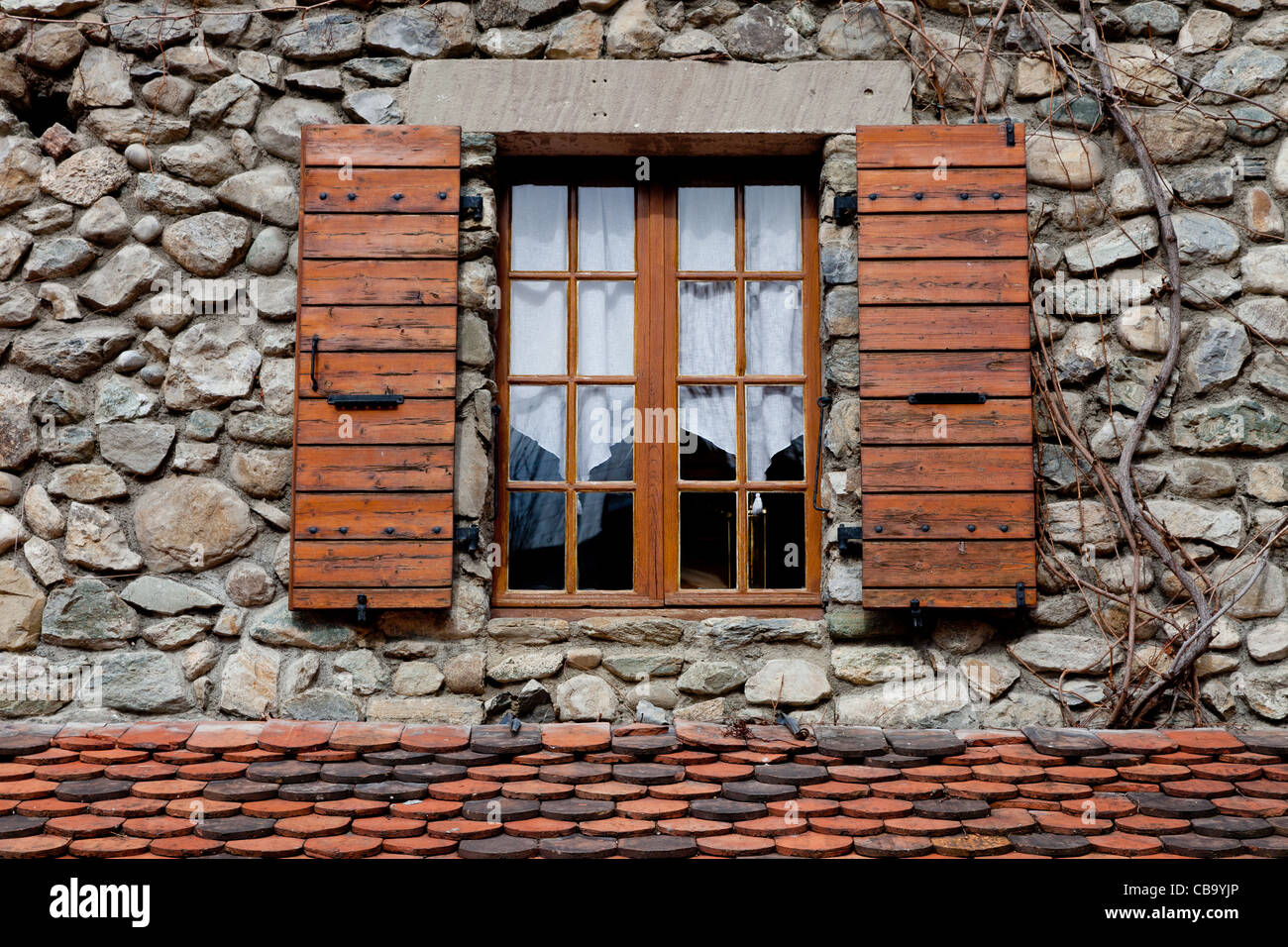 Typische Fenster auf einem Stein gebautes Haus in Frankreich mit hölzernen Fensterläden Stockfoto
