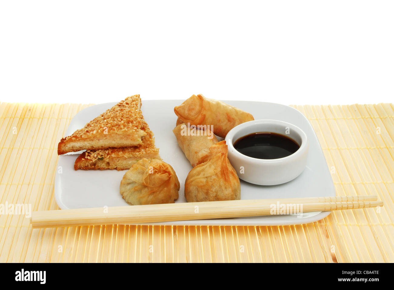 Auswahl der chinesischen snacks auf einem Teller mit Stäbchen und ein Töpfchen von Soja-Sauce auf einem Bambus-Matten Stockfoto