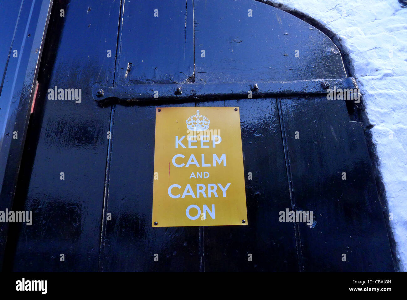 Die bekannte britische Moral Förderung von Weltkrieg zwei Slogan "Keep Calm and Carry On" Schild auf einer alten Holztür. Stockfoto