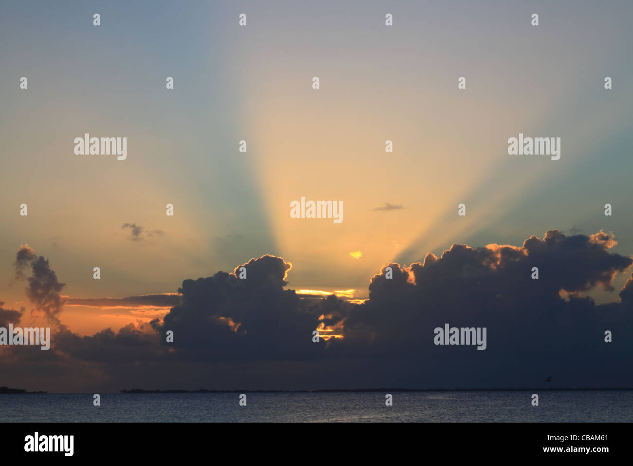 Sonnenuntergang mit Sonnenstrahlen auf Manihi-Atoll im Südpazifik mit Kokospalmen Stockfoto