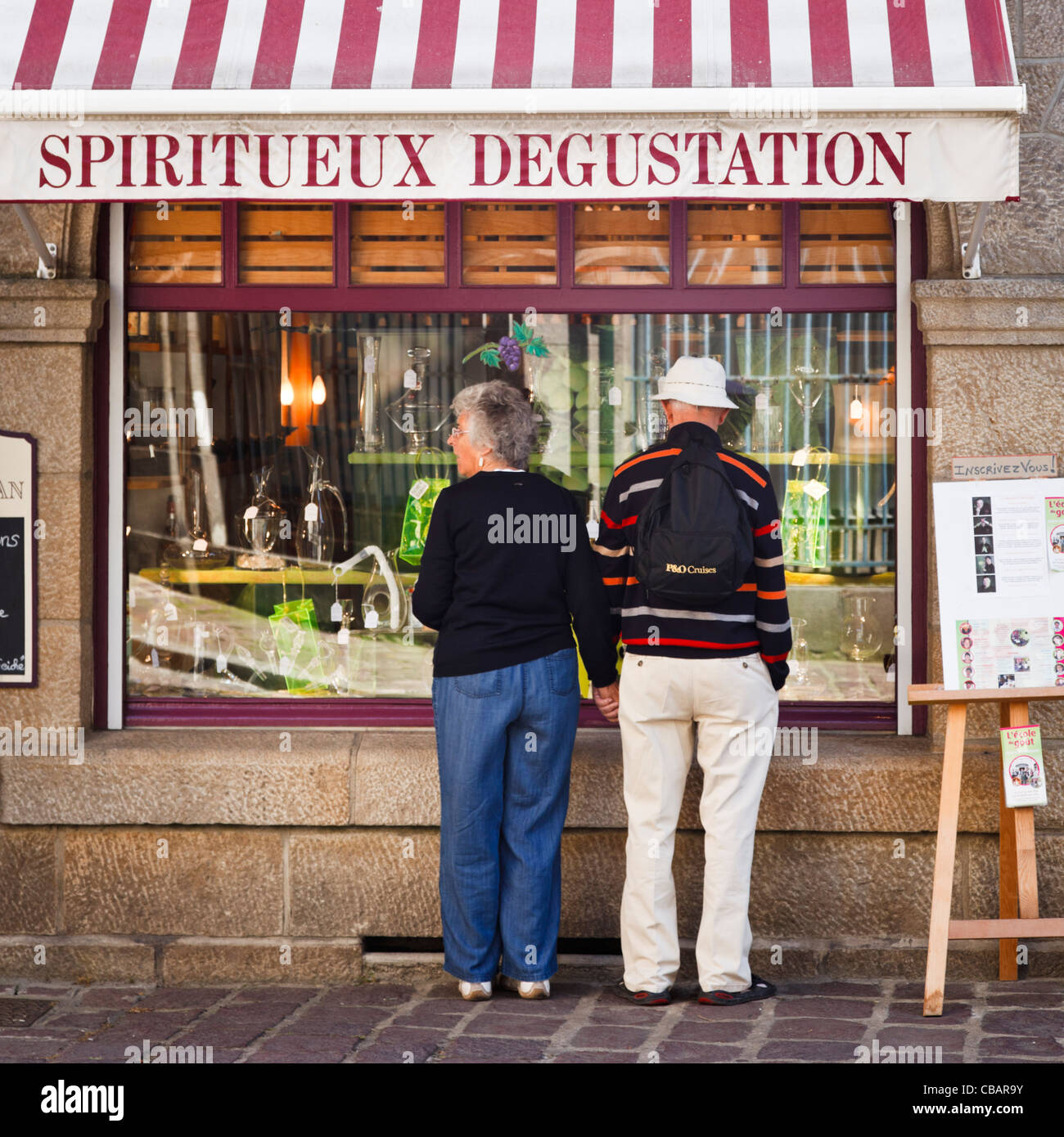 Menschen Fenster Einkaufen in Frankreich an einem Wein Händler Shop, St Malo, Bretagne, Frankreich Stockfoto