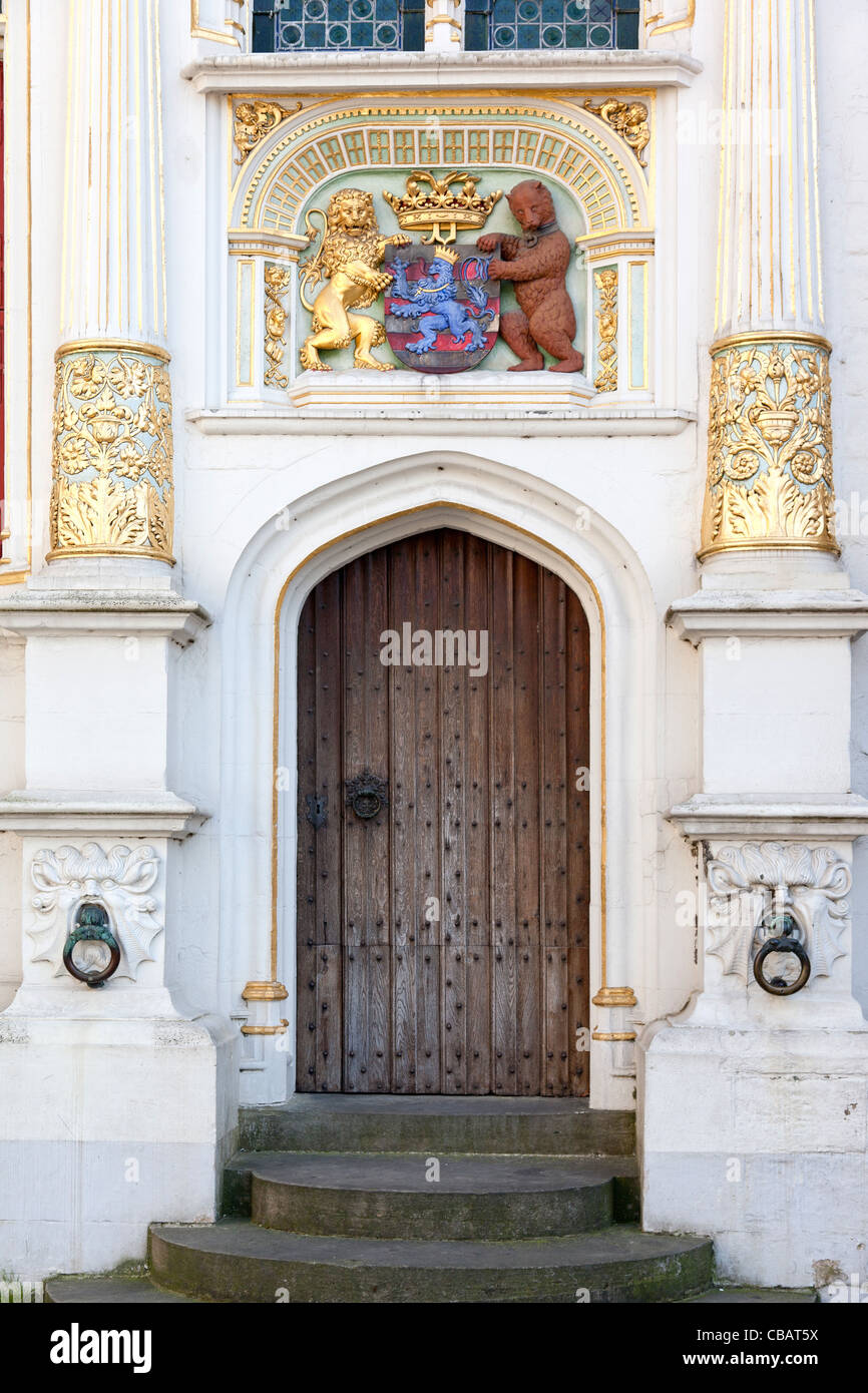 Mittelalterliche Tür und Wappen in einem renovierten Gebäude in Brügge, Belgien Stockfoto