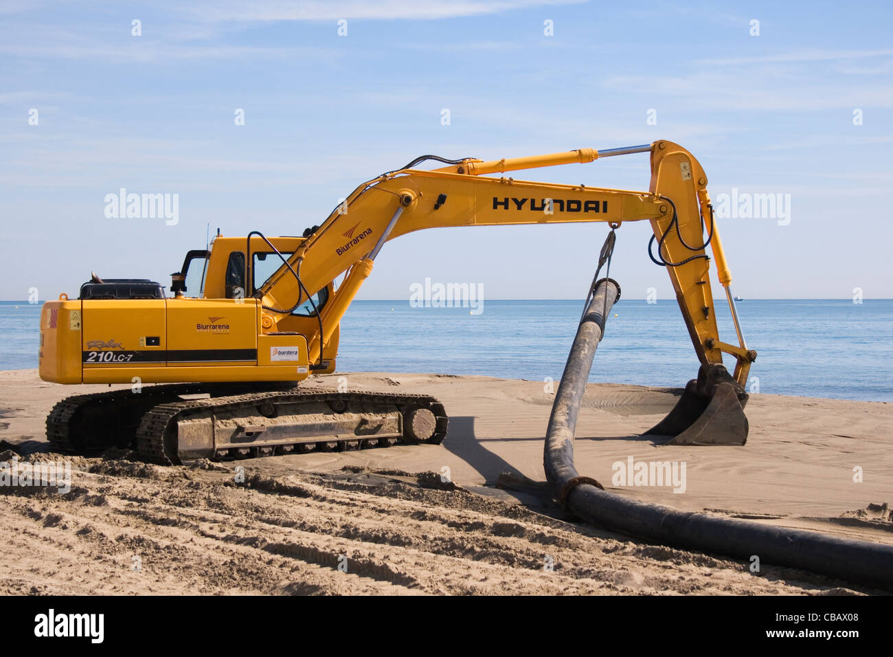 Maschine verwendet, um Sand zu regenerieren, weggespült worden, am Meer am spanischen Strand. Stockfoto