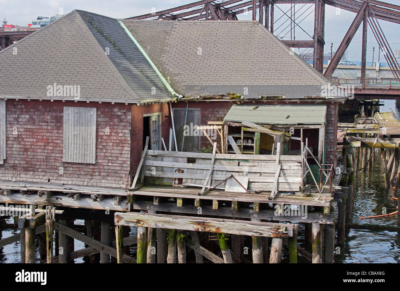 rustikale alte Fischerei-Hütte am dock im Hafen von Boston vor verwitterte rostige Brücke Stockfoto