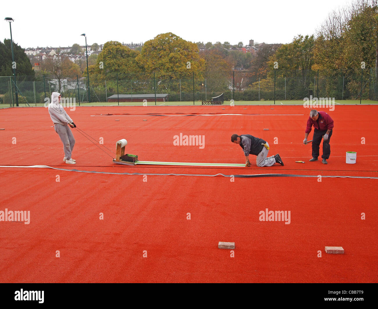 Bau von synthetische Sand-Tennisplätze - schneiden in den weißen "Linien" in die Stabilität-Basis Stockfoto