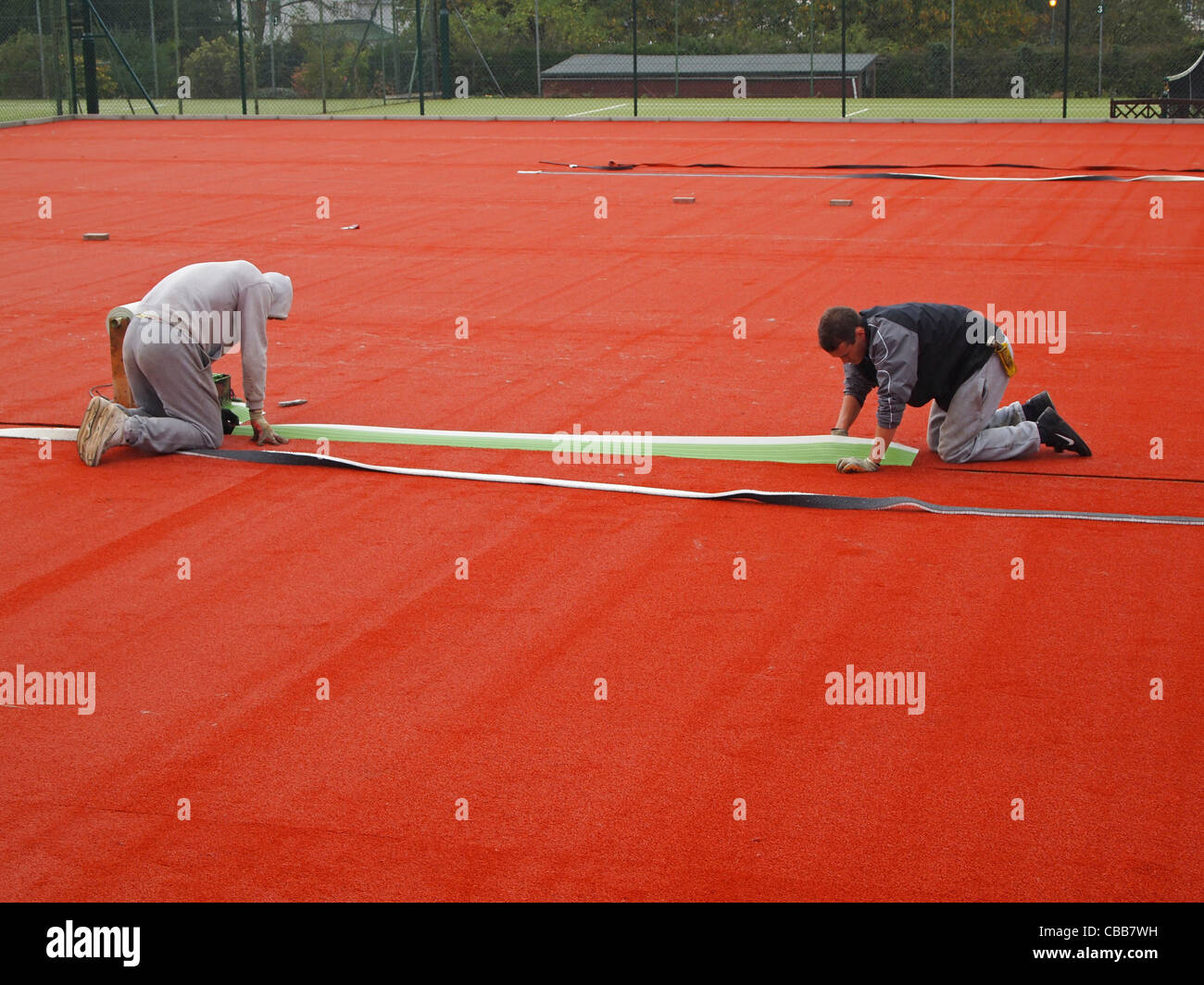 Bau von synthetische Sand-Tennisplätze - schneiden in den weißen "Linien" in die Stabilität-Basis Stockfoto